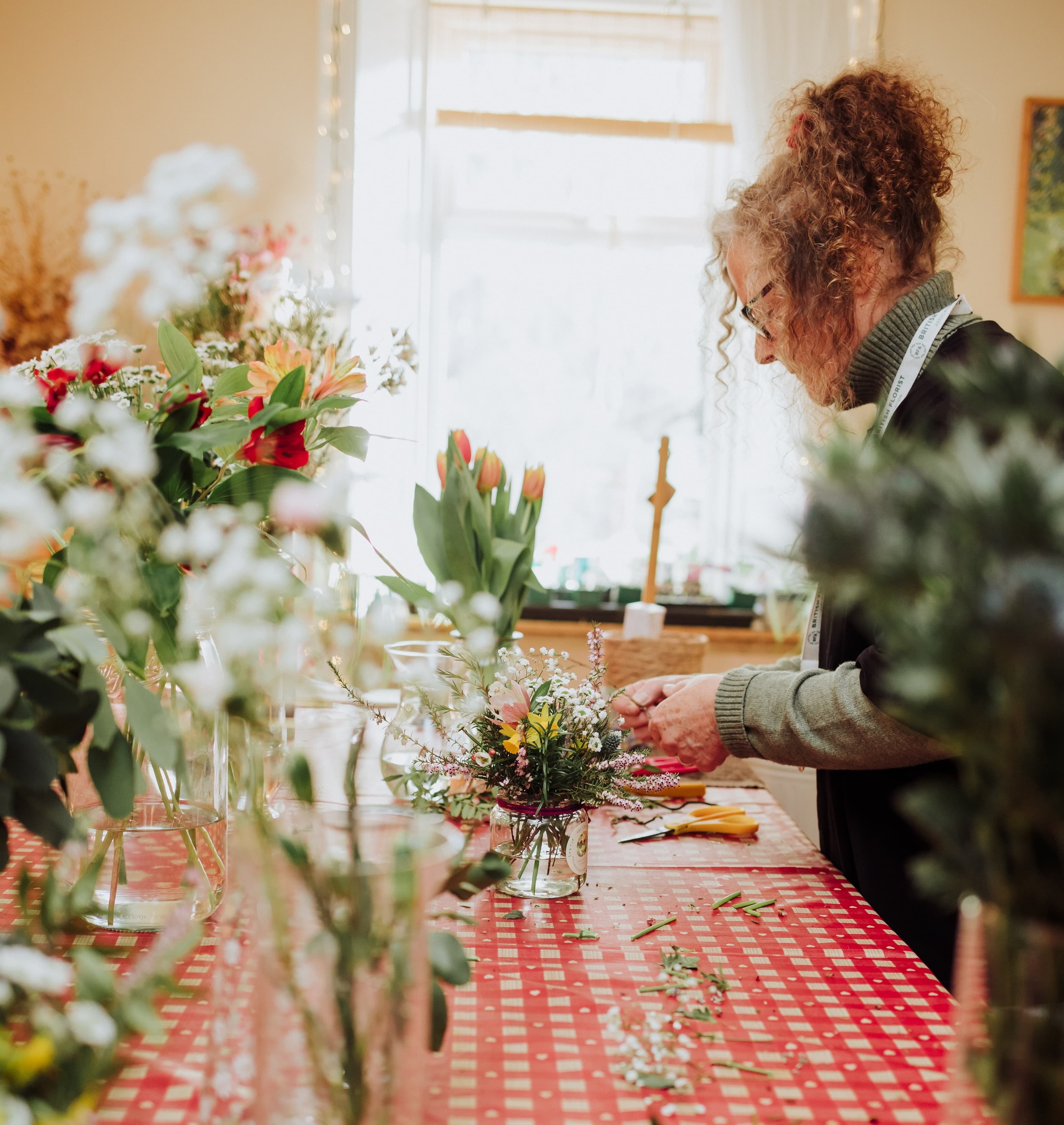 One of the hosts tending to flowers during an indoor event.